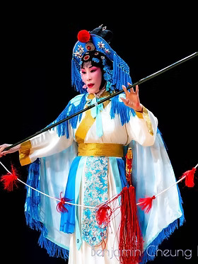 Image of classical Chinese opera singer holding a long stick with a string