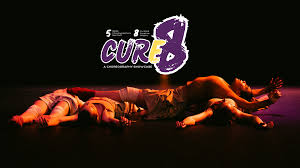 Dancers lying on top of each other under the Cure8 Logo