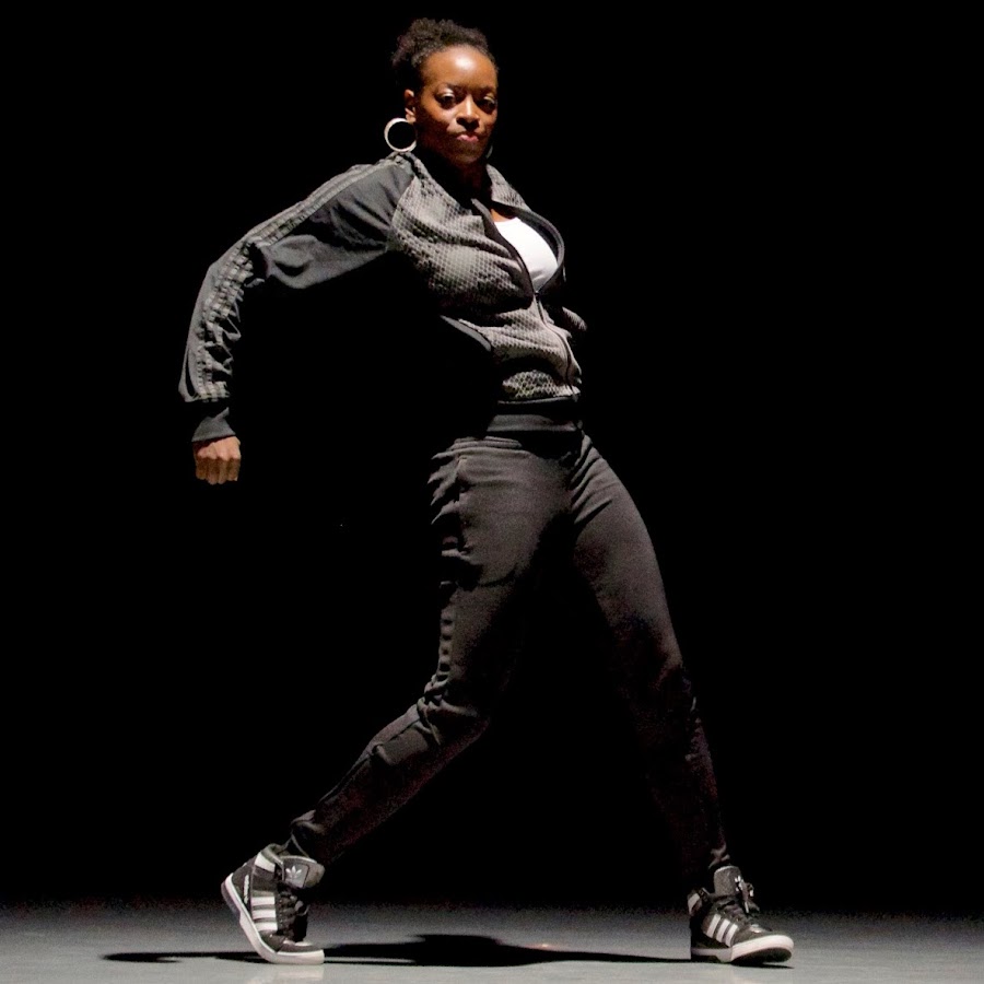 Image of dancer in black with her arm raised